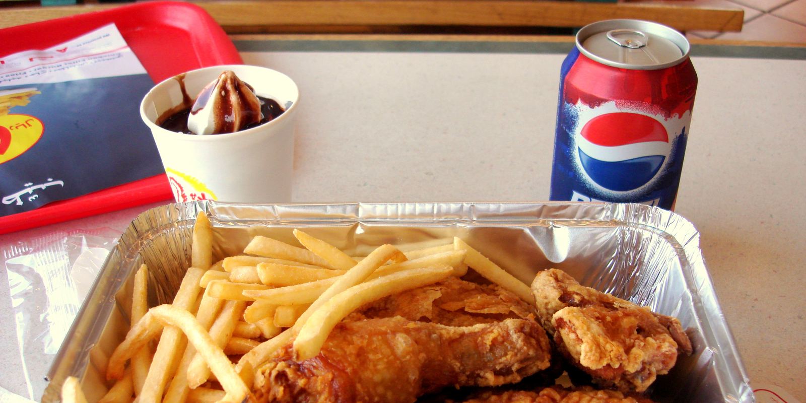 A broasted chicken meal with fries and bread