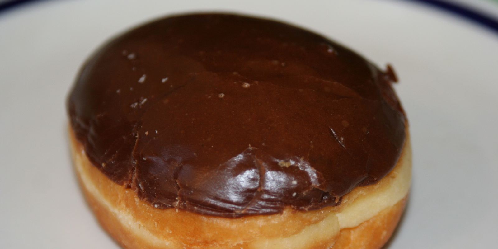 A Boston cream doughnut with chocolate icing