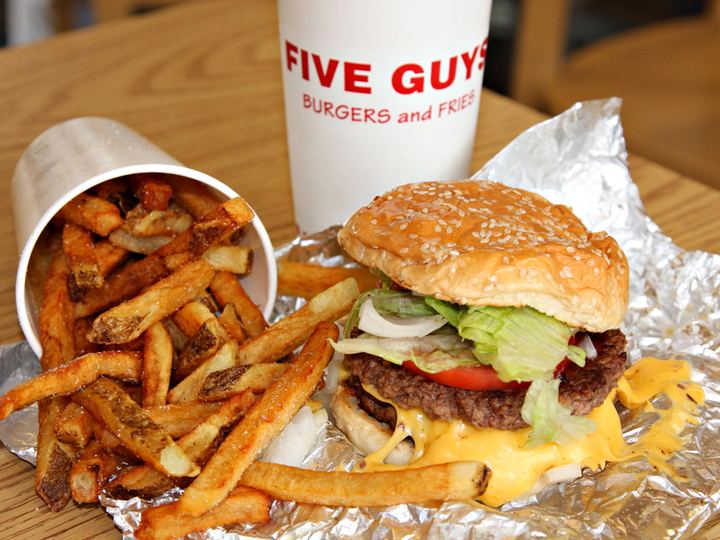 A Five Guys restaurant interior with stacked bags of potatoes